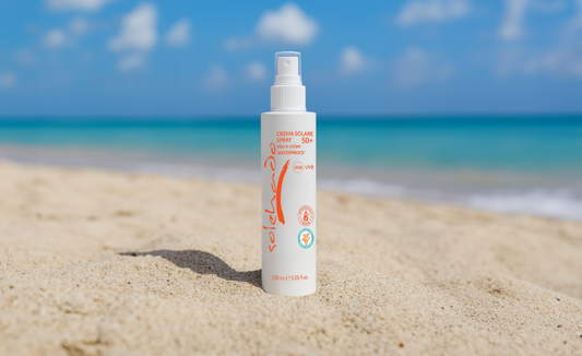 Crema solare spray della linea Solehado di Claride Fitocosmesi, perfetta per la protezione solare a luglio, fotografata sulla spiaggia per rappresentare la massima protezione durante l'estate al culmine.