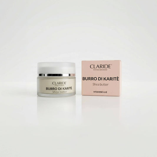Vasetto in vetro satinato che mostra la texture ricca e scatola rosa del Burro di Karitè Claride Fitocosmesi. Trattamento multiuso super nutriente (Shea Butter) arricchito con Vitamine A ed E per riparare la pelle secca, su fondo bianco con riflesso.