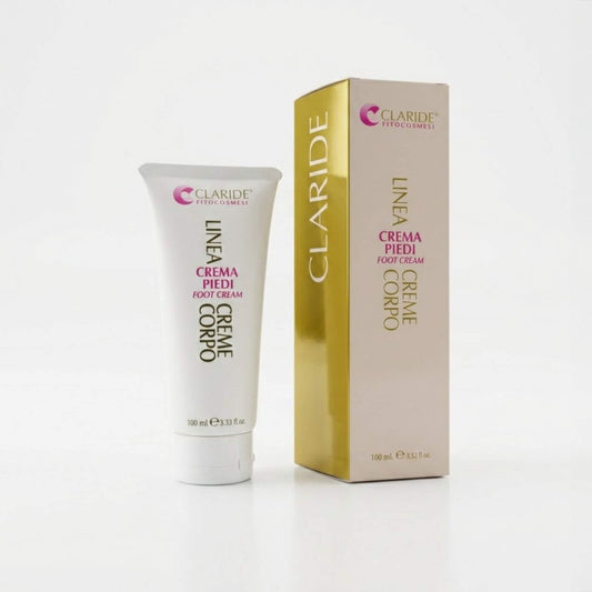 Tubo bianco da 100ml e scatola elegante panna e oro della Crema Piedi Claride Fitocosmesi. Trattamento nutriente e riparatore (Foot Cream) per ammorbidire la pelle secca e i talloni screpolati, su fondo bianco con riflesso.
