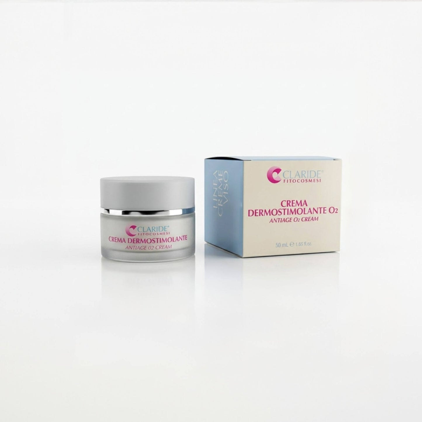 Vasetto in vetro satinato e scatola azzurra e panna della Crema Dermostimolante O₂ Claride Fitocosmesi. Trattamento viso anti-age ossigenante (Antiage O₂ Cream) per rivitalizzare e illuminare la pelle asfittica, su fondo bianco con riflesso.
