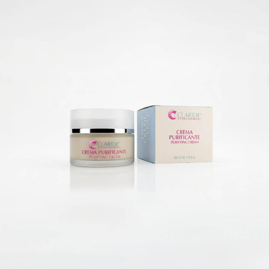 Vasetto in vetro satinato contenente crema dal colore naturale e scatola panna e azzurra della Crema Purificante Claride Fitocosmesi. Trattamento viso opacizzante e sebo-riequilibrante (Purifying Cream) per pelli miste, grasse e con imperfezioni, su fondo bianco con riflesso.