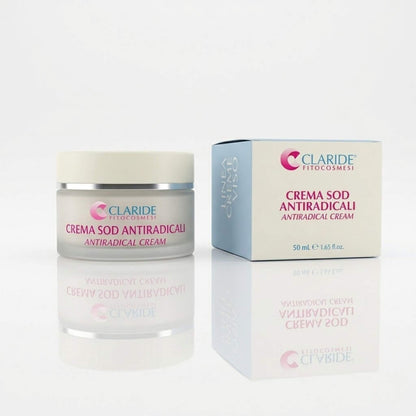 Vasetto in vetro satinato e scatola della Crema SOD Antiradicali a marchio Claride Fitocosmesi. Trattamento della Linea Creme Viso, con testi in italiano e inglese, adagiato su una superficie bianca con riflesso a specchio.