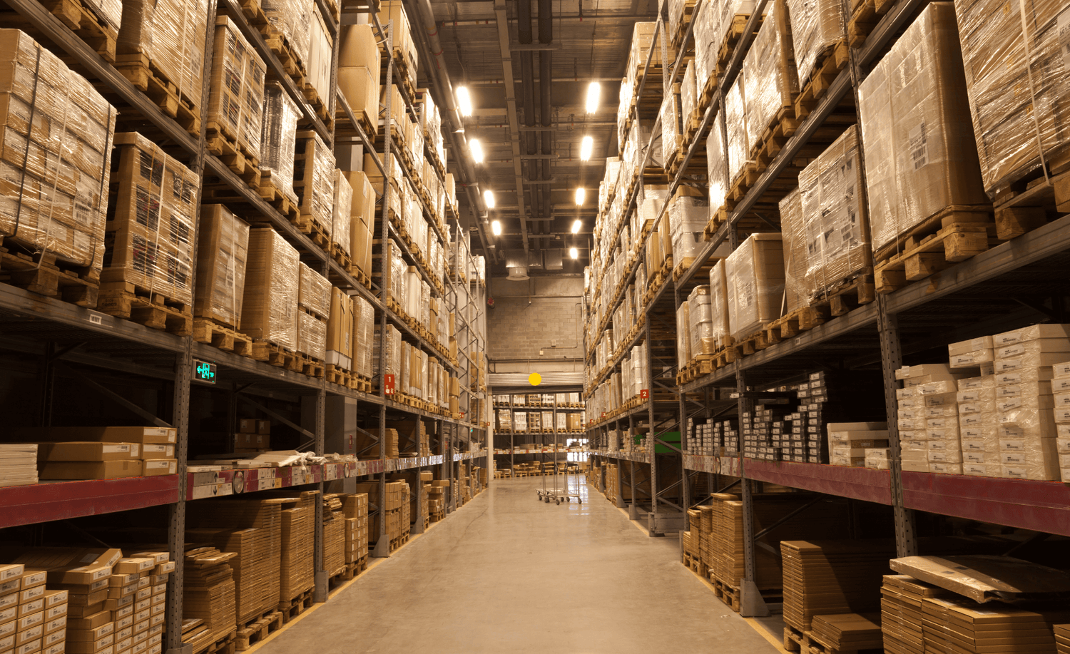 Il magazzino logistico di Claride Fitocosmesi con corsie e scaffalature piene di prodotti pronti per la spedizione.