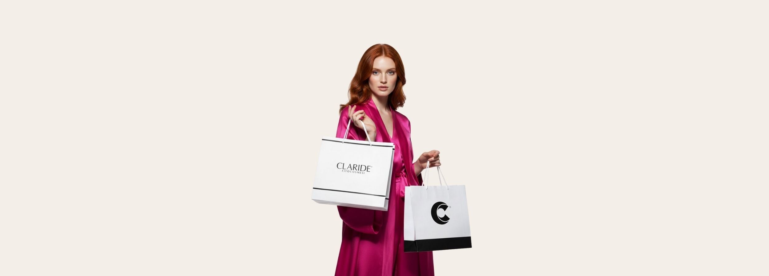 Banner desktop orizzontale iscrizione newsletter Claride Fitocosmesi, modella con shopping bag su sfondo grigio chiaro