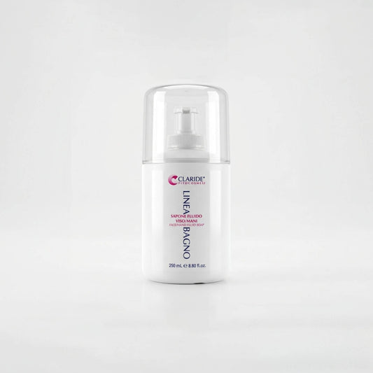 Flacone bianco da 250ml con erogatore a pompetta e tappo trasparente protettivo del Sapone Fluido Viso/Mani Claride Fitocosmesi. Detergente liquido delicato della Linea Bagno per la detersione quotidiana, su fondo bianco neutro con riflesso.