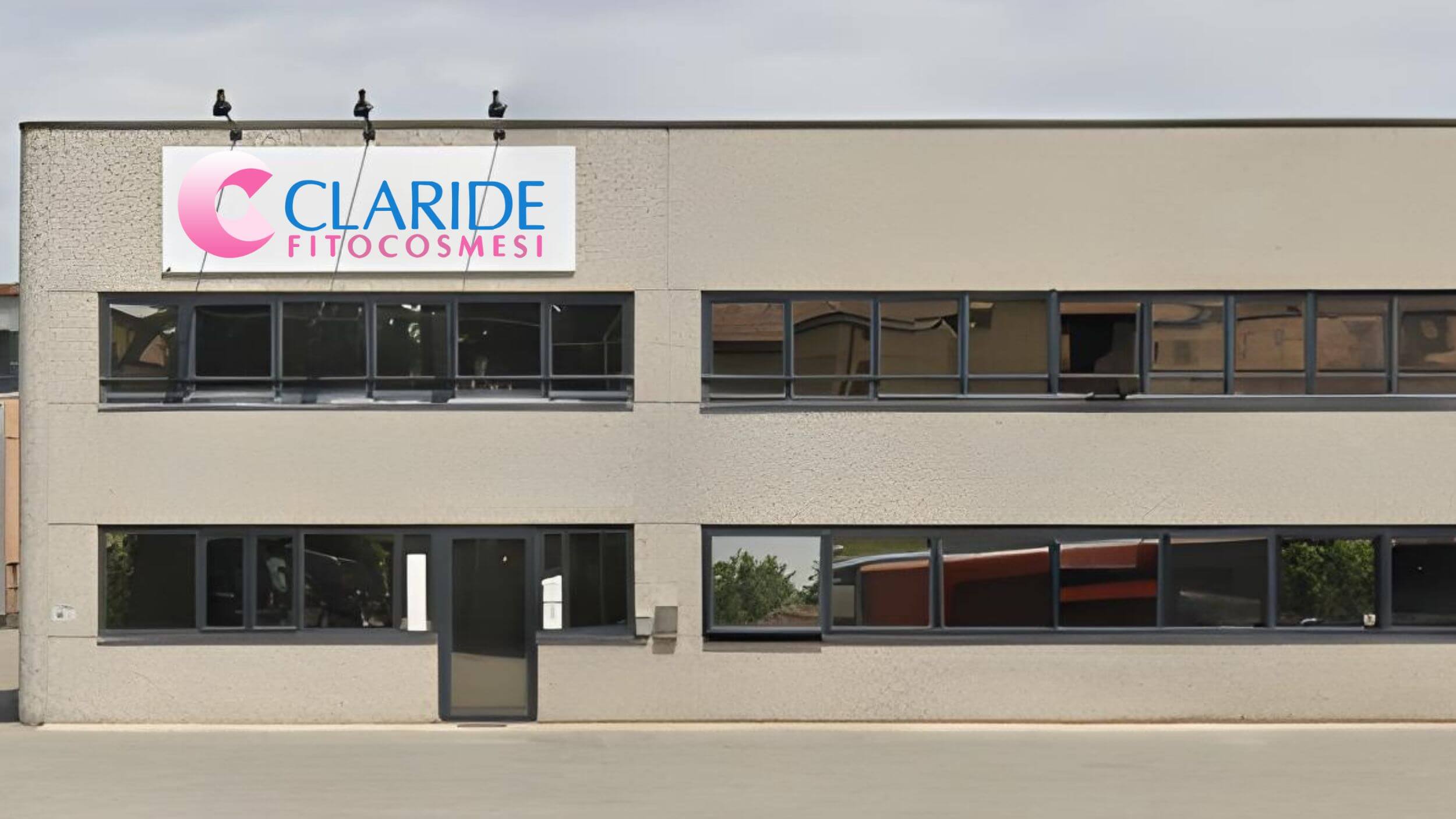 Facciata dell'edificio aziendale di Claride Fitocosmesi, caratterizzata da ampie vetrate e dalla grande insegna con il logo ufficiale.