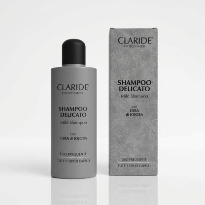 Flacone e scatola grigio satinato dello Shampoo Delicato Claride Fitocosmesi con Cera di Jojoba. Trattamento Mild Shampoo per uso frequente adatto a tutti i tipi di capelli, su fondo bianco con riflesso.