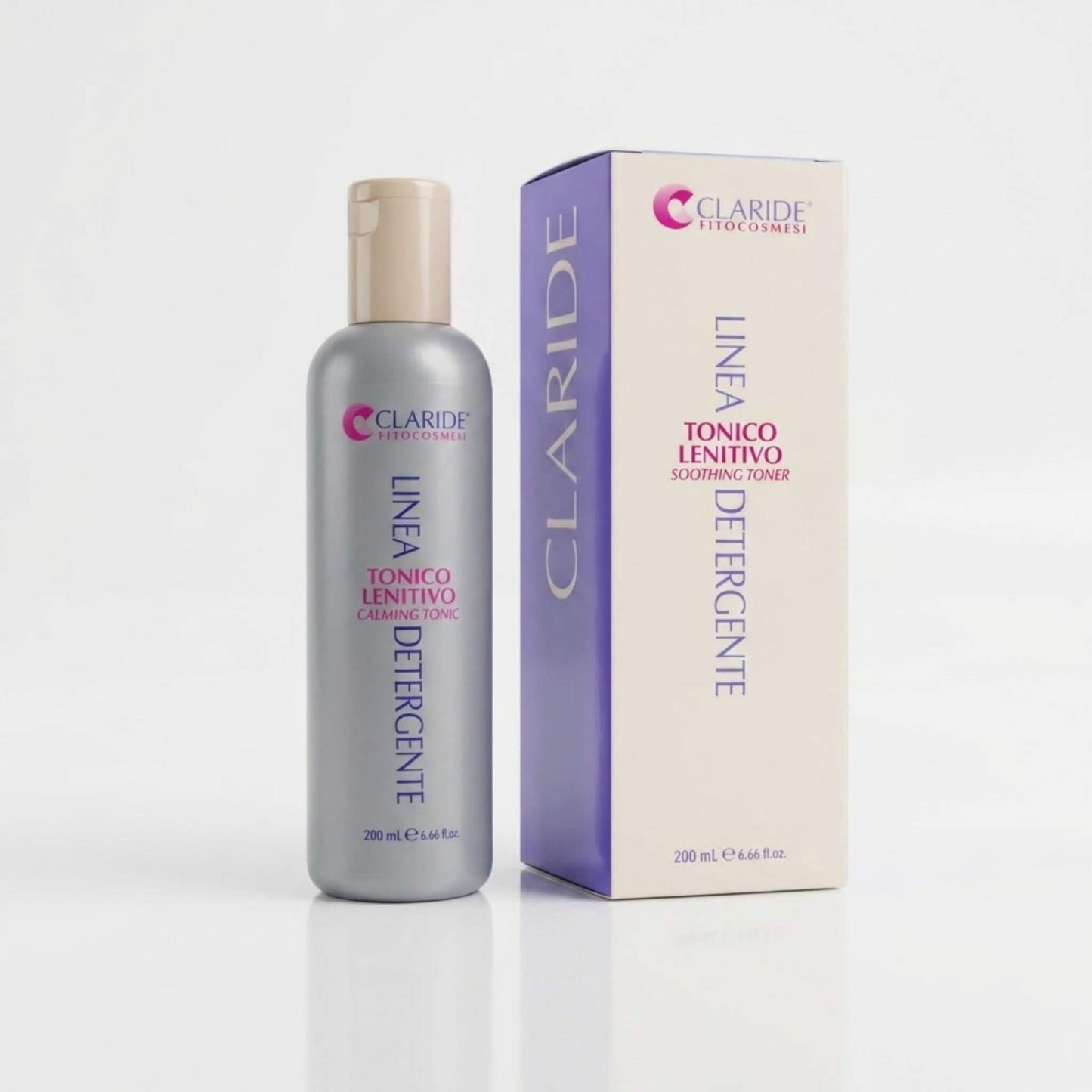 Flacone grigio e scatola panna con pannello laterale lilla del Tonico Lenitivo Claride Fitocosmesi. Lozione viso rinfrescante e decongestionante (Soothing Toner) della Linea Detergente, ideale per calmare rossori e irritazioni delle pelli sensibili, su fondo bianco con riflesso.