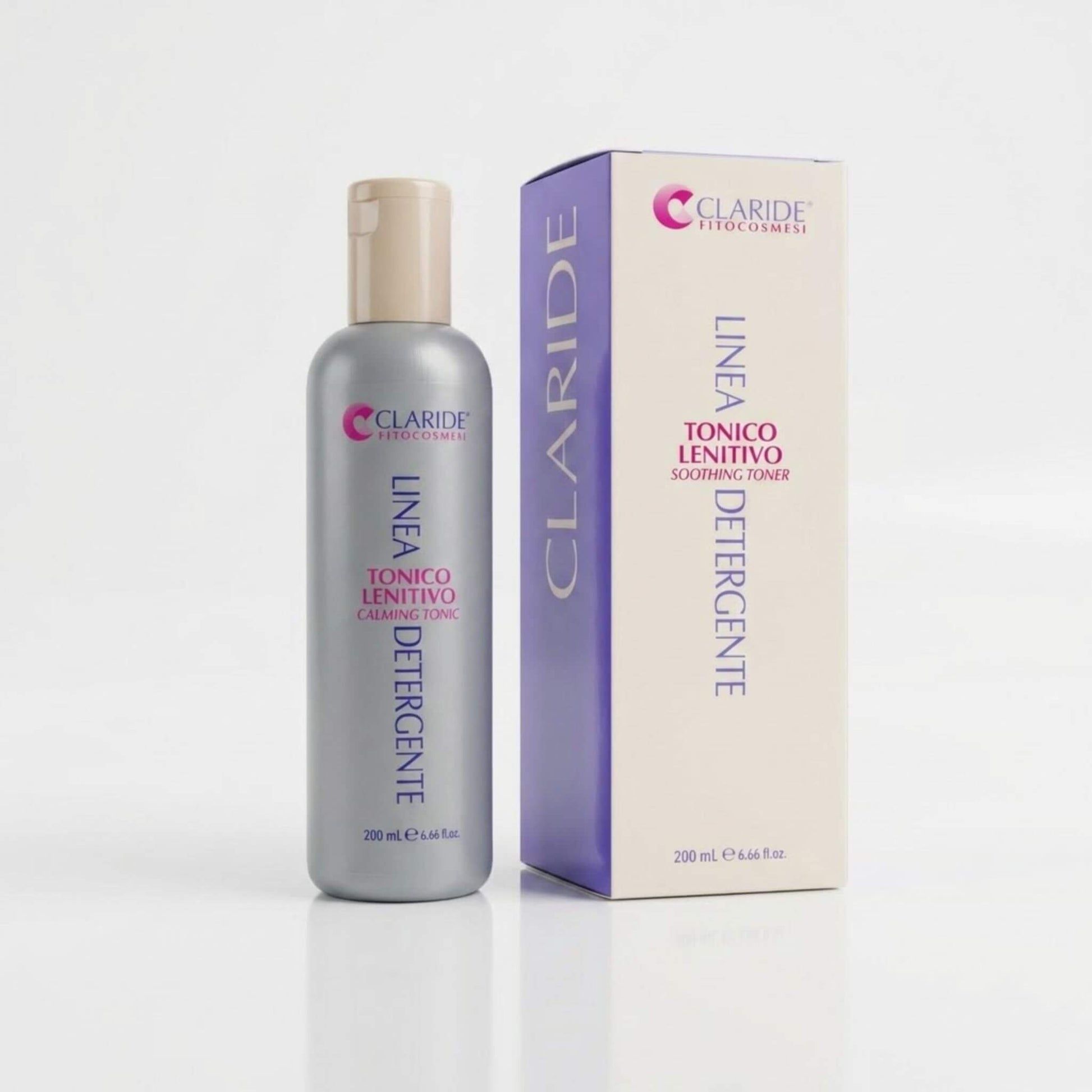 Flacone grigio e scatola panna con pannello laterale lilla del Tonico Lenitivo Claride Fitocosmesi. Lozione viso rinfrescante e decongestionante (Soothing Toner) della Linea Detergente, ideale per calmare rossori e irritazioni delle pelli sensibili, su fondo bianco con riflesso.