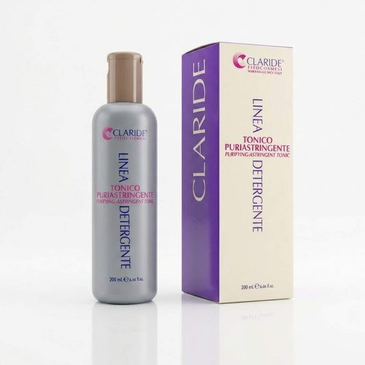 Flacone grigio e scatola panna con pannello viola del Tonico Puriastringente Claride Fitocosmesi. Lozione viso purificante e astringente (Purifying-Astringent Tonic) formulata per minimizzare i pori dilatati e opacizzare le pelli miste e impure, su fondo bianco con riflesso.